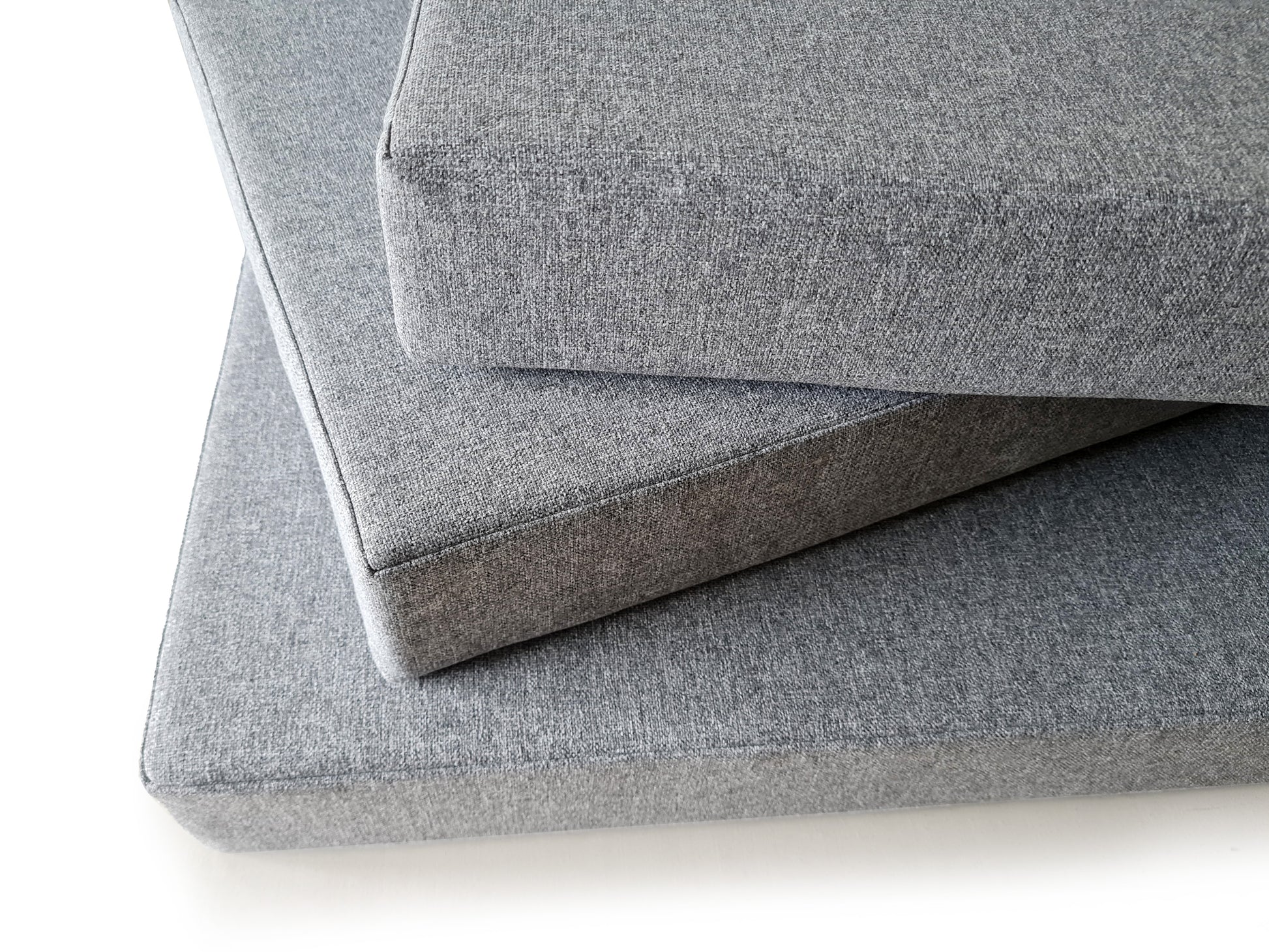 Three neat luxury bench cushions in a hard wearing, machine-washable light grey semi plain upholstery fabric. The cushions look very well-made and comfortable. The cushions have 10cm thick firm foam inside which has a stockinette wrap. Clean, unpiped edges for a minimalist, scandi look finish. Light grey stain resistant hardwearing fabric bench cushion covers with fire safe firm foam inside. Long zips at the back and no beading on the edges. Machine washable kid and pet friendly fabric, kitchen