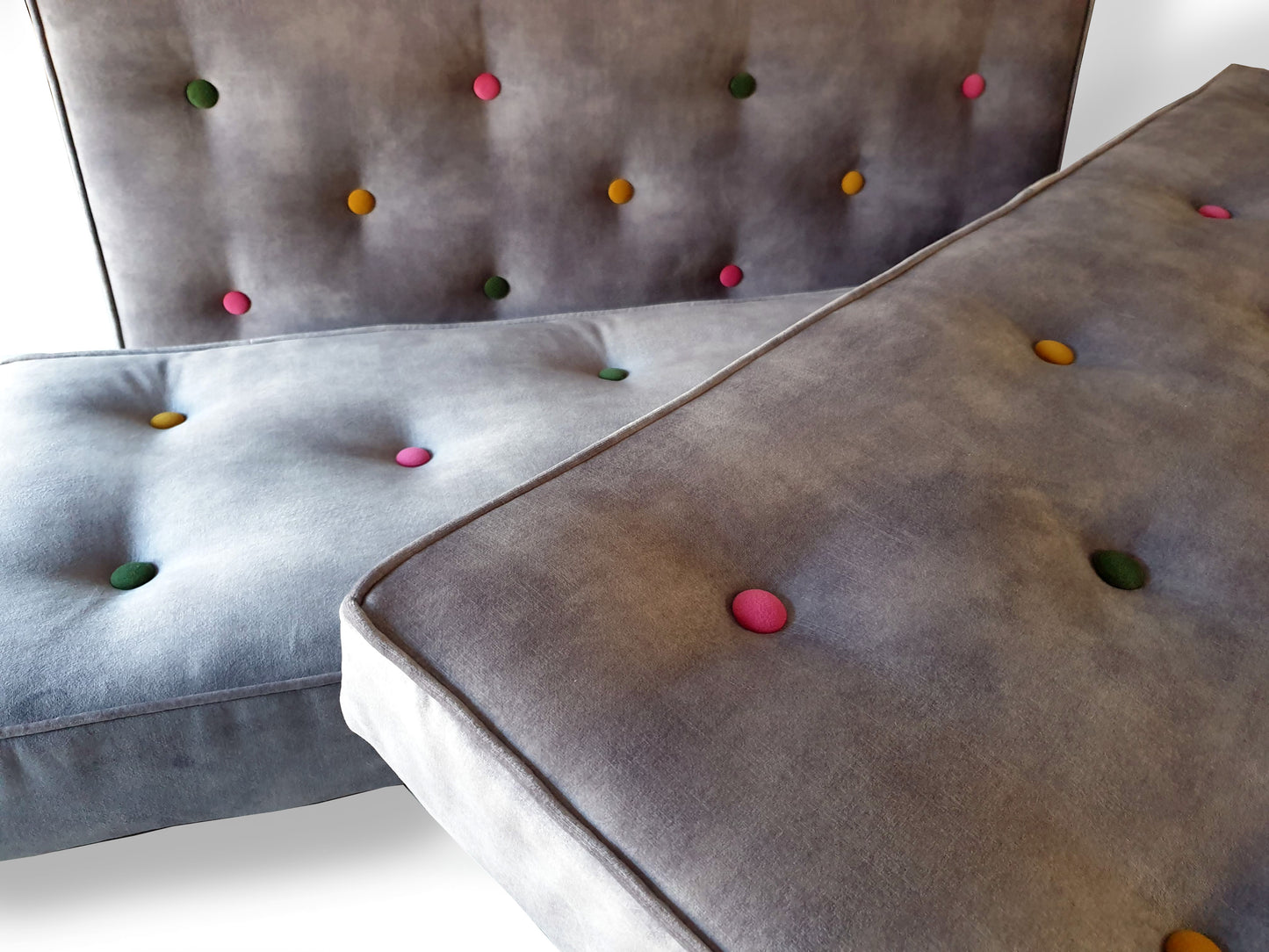 High quality velvet bench cushions in a light grey colour upholstery velour fabric with a slight mottled, semi plain pattern. The thick firm foam seating cushions have dacron on the foam and stockinette wrap. The comfortable and supportive dining banquette seat cushions are button tufted by hand with multicoloured buttons. Perfect for dinette seating. Wipe clean and stain resistant covers. Kept in place with velcro strips, ties which can be hung from a mounted rod or anti slip cloth.