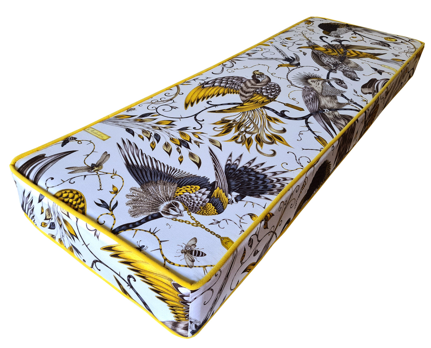 A custom made to order bench cushion with designer cotton fabric cover with tropical birds in bright yellow and black pattern on a white background. Natural fibre bench cushion with a thick, firm foam insert. Contrast bright yellow velvet piping at the edges and a zip at the back so the cover can be cleaned. Designer bench cushions made with high quality materials in the UK by a small local company. Firm, supportive upholstery foam for dining bench seating banquette booths. 