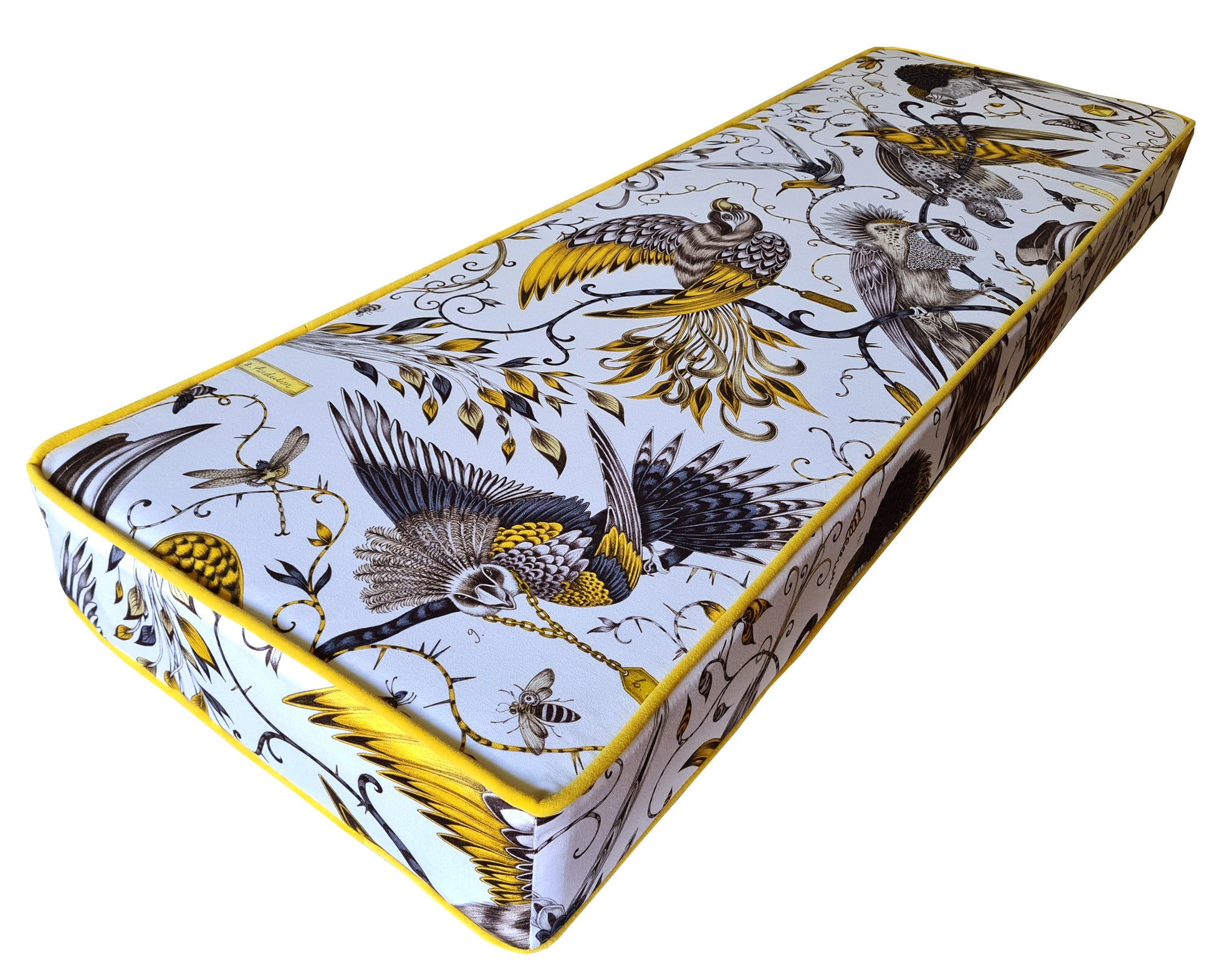 A custom made to order bench cushion with designer cotton fabric cover with tropical birds in bright yellow and black pattern on a white background. Natural fibre bench cushion with a thick, firm foam insert. Contrast bright yellow velvet piping at the edges and a zip at the back so the cover can be cleaned. Designer bench cushions made with high quality materials in the UK by a small local company. Firm, supportive upholstery foam for dining bench seating banquette booths. 