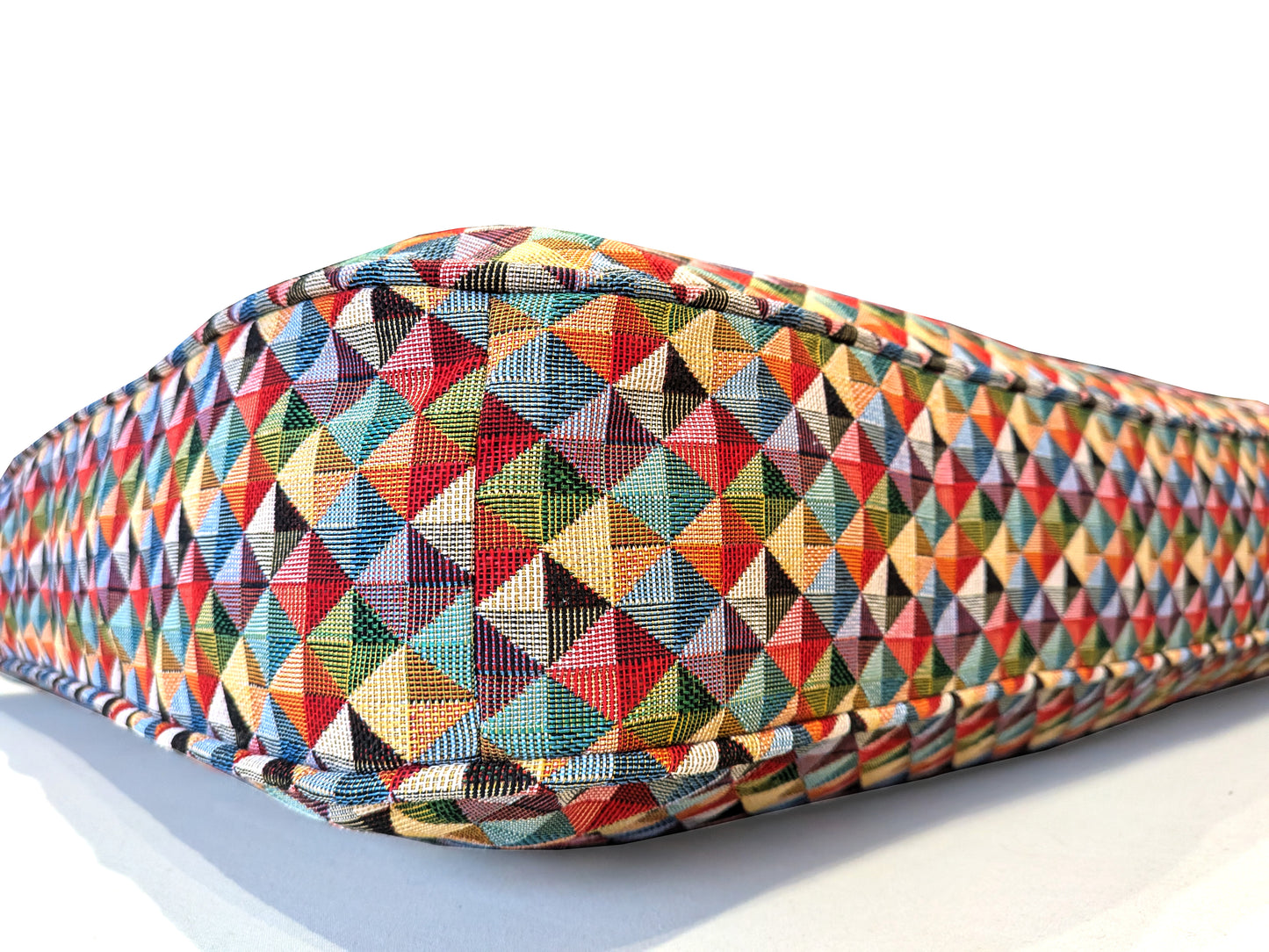 A large duck feather and soft foam indoor bench cushion made to measure in a brightly coloured multicolour geometric patterned cotton upholstery fabric. Statement cushion in red, blue, white, yellow colours. Made to measure indoor bench cushion with soft hollow fibre filling. Sheep wool insert for sofa style cushion. Thick, high quality, supportive shaped bench cushion with piping at the edges and zipper at the back of the cover. Plastic free cushion options. Latex rubber, fire chemical free