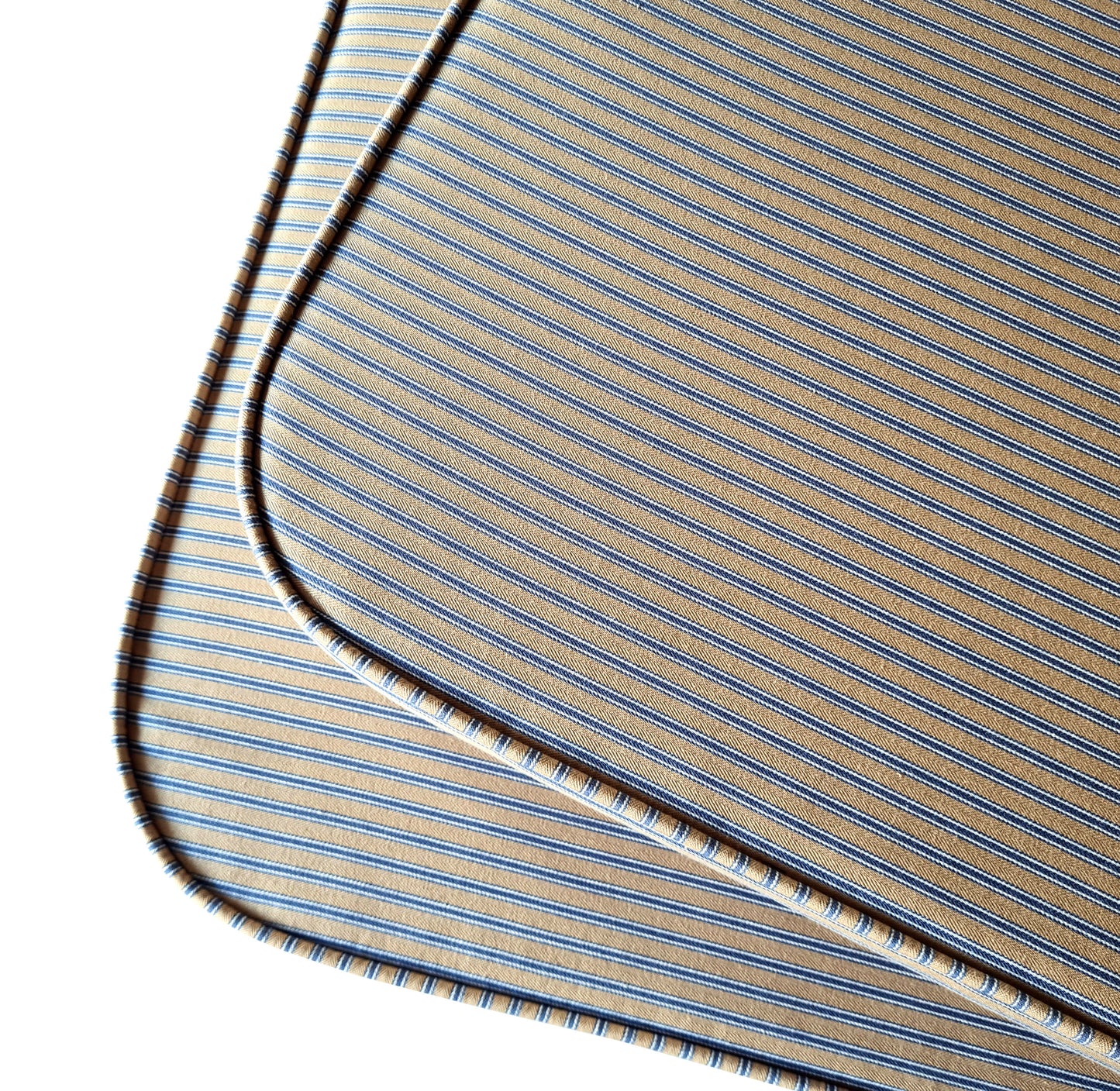 Two shaped bench seat cushions with rounded corners in a 100% cotton french style ticking fabric in a beige and blue stripe. The curved corner window ledge cushions has neat piping at the edges for long lasting seams. The banquette seat cushions have firm upholstery foam inside which is long lasting and fire safe. The natural fibre fabric bench cushion covers have zips at the back for cleaning. The stain resistant bench cushions have been made to measure for a perfect fit for any space or shape.