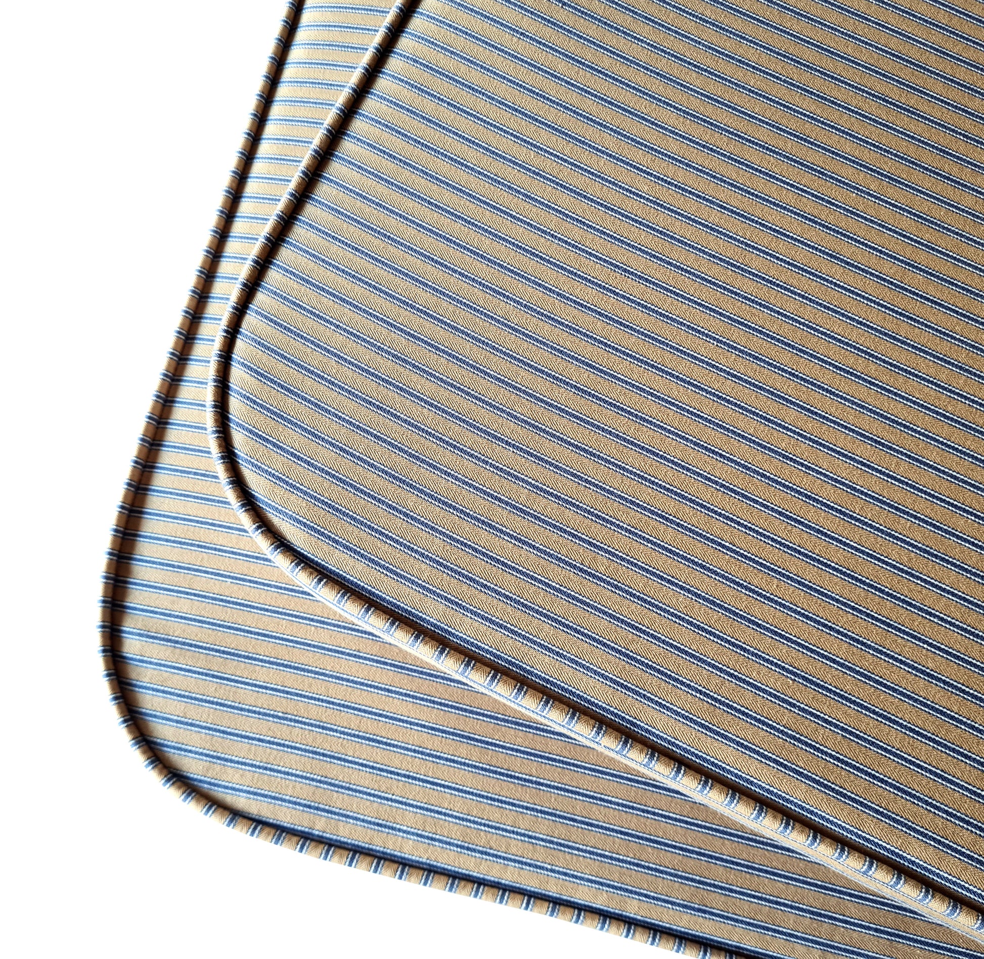 Two shaped bench seat cushions with rounded corners in a 100% cotton french style ticking fabric in a beige and blue stripe. The curved corner window ledge cushions has neat piping at the edges for long lasting seams. The banquette seat cushions have firm upholstery foam inside which is long lasting and fire safe. The natural fibre fabric bench cushion covers have zips at the back for cleaning. The stain resistant bench cushions have been made to measure for a perfect fit for any space or shape.