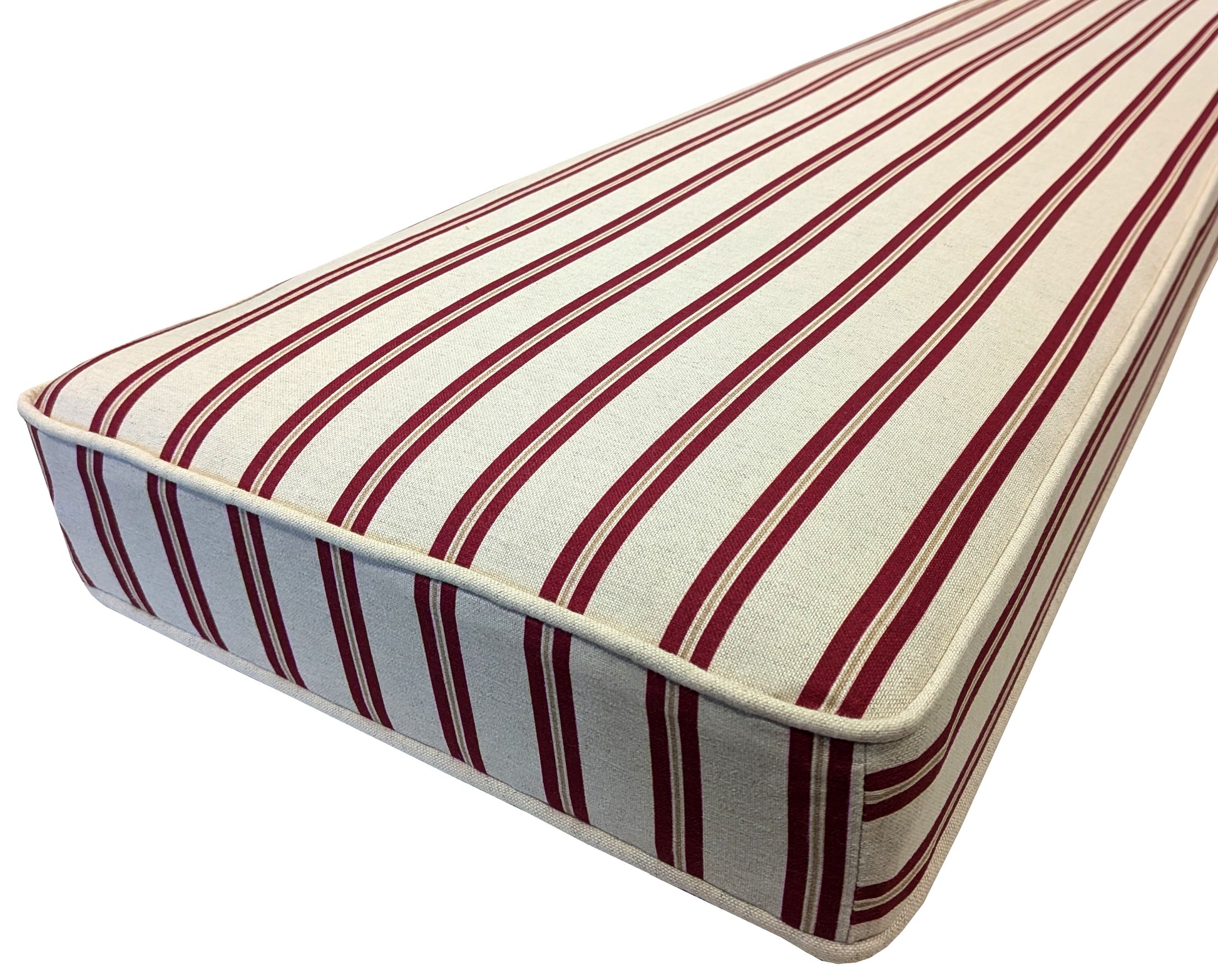 A thick bespoke bench cushion with red cream and yellow candy stripes. The medium foam, supportive, comfortable window seat cushion has natural fibre cover made from linen and cotton mix fabric. The indoor bench cushion has cream piping at the edges. The stain resistant dining nook cushion has a long zip to remove the cover. Child friendly bench cushion with stain resistant treatment. Plastic free banquette seating cushion. Back cushion pad, custom made shaped bench cushion with dacron and zip