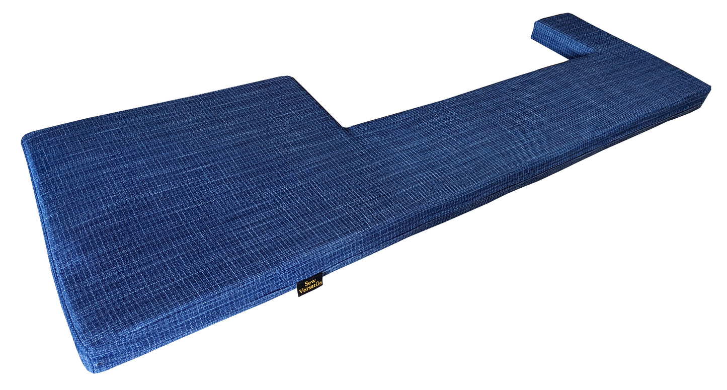 A long bench cushion with a large rectangular cut out at the front in a dark denim blue linen look machine washable upholstery fabric. The firm foam back cushion has shaping to fit around a window ledge. The back pad cushion has no piping at the edges, no welt or beading. There is a zip along one edge of the box edge cushion so the cover can be removed for washing. Kitchen storage dining banquet space seating cushion for a storage cupboard bench extra seating, made in UK, yorkshire, hard wearing